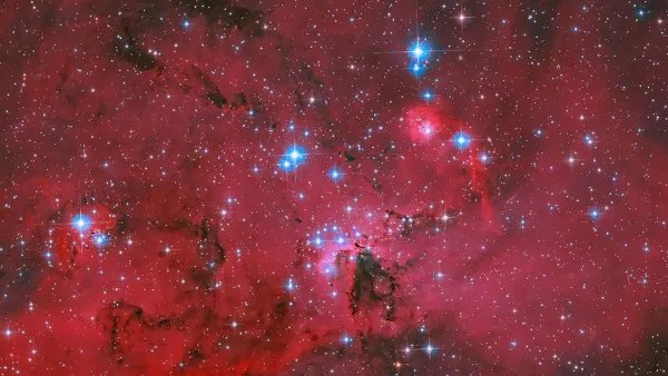 Hubble'dan Nefes Kesen Görüntü: Mavi ve Beyaz Yıldızlarla Parlayan Kızıl Bir Yıldız Doğumevi