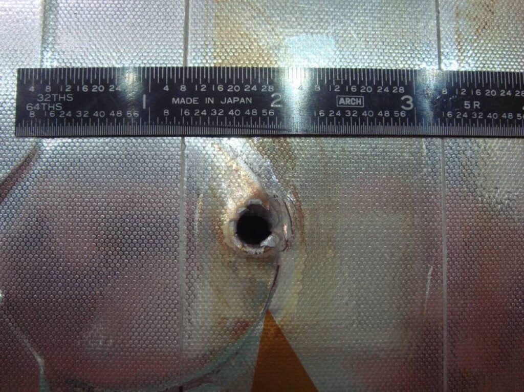 Space Shuttle Endeavour had a major impact on its radiator during STS-118. The entry hole is about 5.5 mm (0.22 in), and the exit hole is twice as large