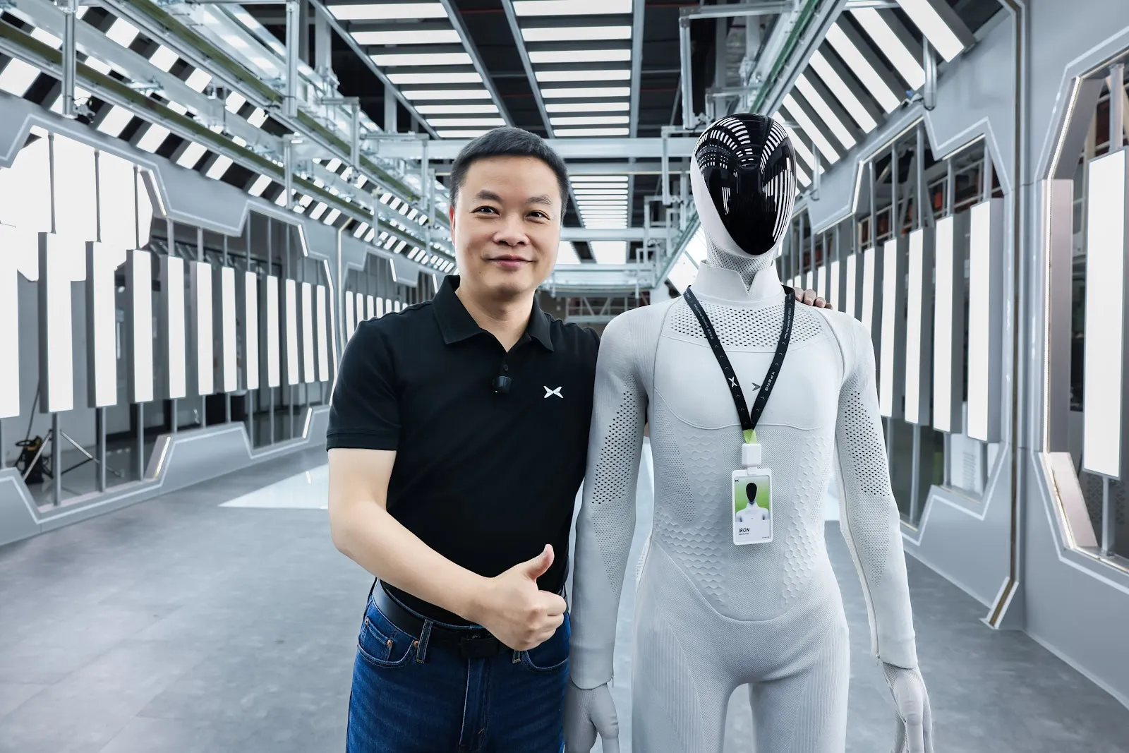 He Xiaopeng standing next to the XPeng IRON humanoid robot